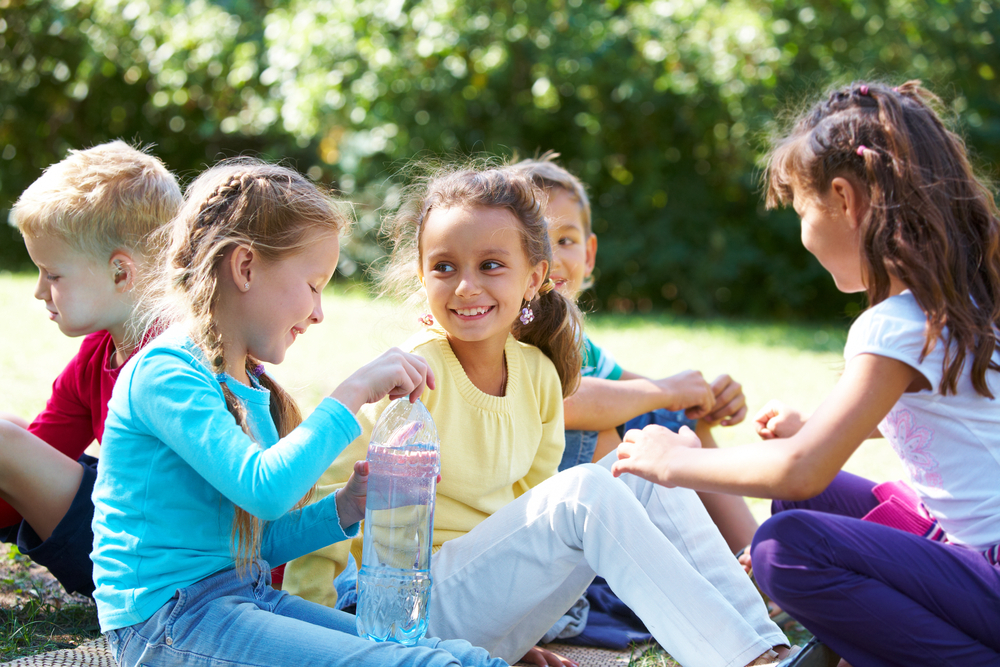Children enjoying a picnic outdoors on a sunny day.
